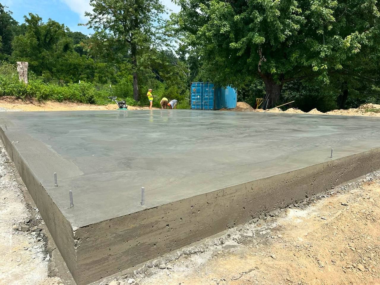 Large fresh concrete slab, just finished, with woods behind